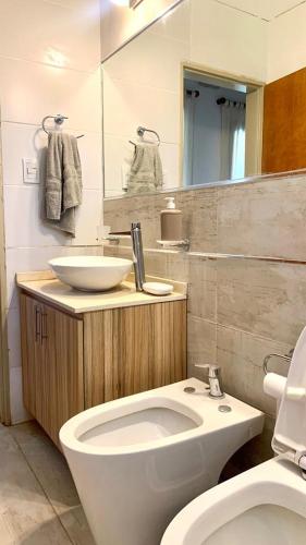 a bathroom with a white toilet and a sink at La Casita de Karen in Villa General Belgrano