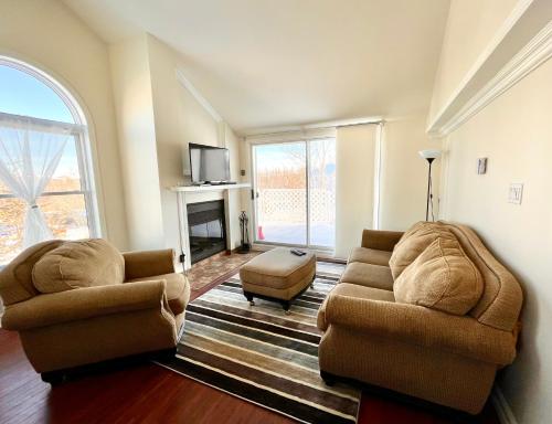 a living room with two chairs and a fireplace at Chaleureux condo à Magog in Magog-Orford