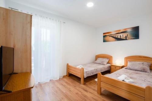 two beds in a room with a tv and a bed sidx sidx sidx at Vacation villa Matic with 7 bedrooms in Sinj