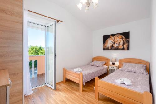 a bedroom with two beds and a window at Vacation villa Matic with 7 bedrooms in Sinj