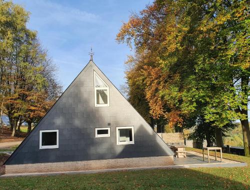 a small black church with a cross on the roof at Aux 4 vents - Malmedy in Malmedy