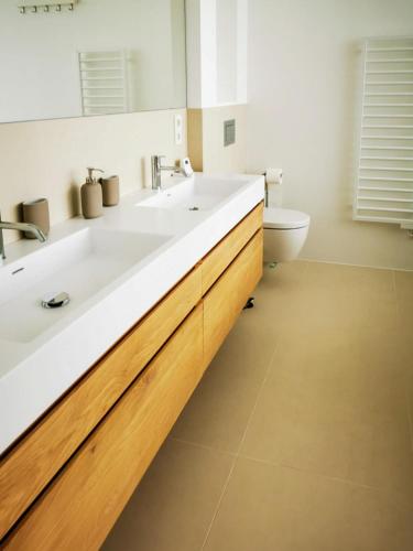 a bathroom with two sinks and a toilet at Seehaus LakeSide - Am Hafen in Neusiedl am See