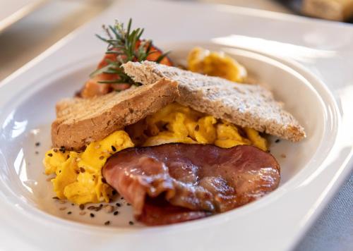a plate of breakfast food with a sausage and toast at Relais Uffizi in Florence