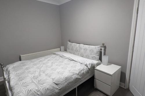 a small bedroom with a bed and a night stand at Apt 2, Oakwood Residence in Killingbeck