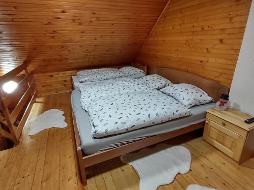 Cama en habitación de madera con suelo de madera en Brunarica 6A - Smučišče Trije Kralji, en Oplotnica