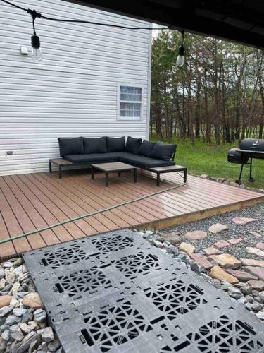a couch sitting on a patio with a table at Quiet Private House w Hot Tub/Fire pit/Games in Blakeslee