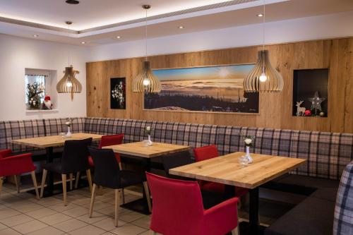 レールンバッハにあるLandhotel Eiblの木製テーブルと赤い椅子が備わるレストラン
