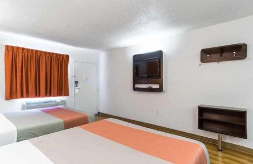 um quarto de hotel com duas camas e uma televisão de ecrã plano em Beachside Inn em Anaheim