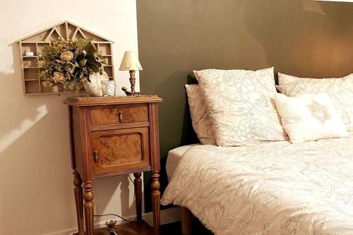 a bedroom with a bed and a night stand with a lamp at Grand appartement place Saint-Pierre, proche Château de Saumur et bord de Loire" in Saumur