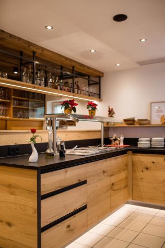 a kitchen with wooden cabinets and a black counter top at Landhotel Eibl in Röhrnbach