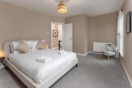 a bedroom with a white bed and a chair at Air Host and Stay - Talton House, sleeps 5, 7 minutes drive to city centre, free parking in Liverpool