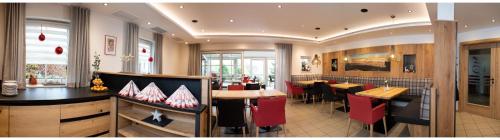 a restaurant with a bar with red chairs and tables at Landhotel Eibl in Röhrnbach
