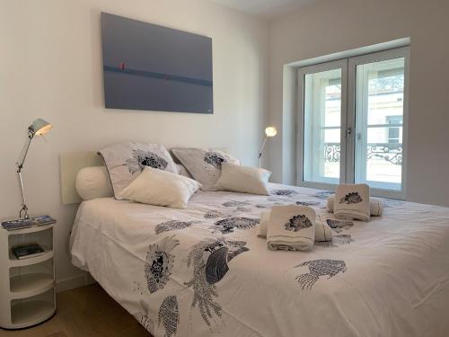 a bedroom with a large white bed with pillows at LE TI ROCHELAIS, superbe appart, design, cosy, vieux-port au calme in La Rochelle