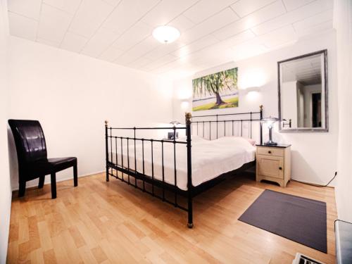1 dormitorio con cama, silla y espejo en Ferienhaus SEERESIDENZ am Mühlensee, en Godern