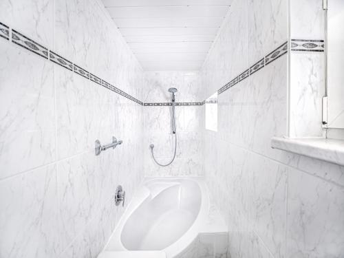 a white bathroom with a shower and a sink at Ferienhaus SEERESIDENZ am Mühlensee in Godern