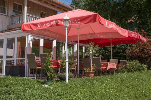 a red umbrella sitting in front of a restaurant at Landhotel Eibl in Röhrnbach