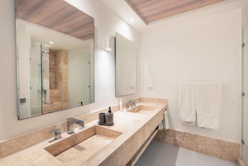 La salle de bains est pourvue de 2 lavabos et d'un miroir. dans l'établissement 2BR Apartment at Aquarella AG02, à Juan Dolio