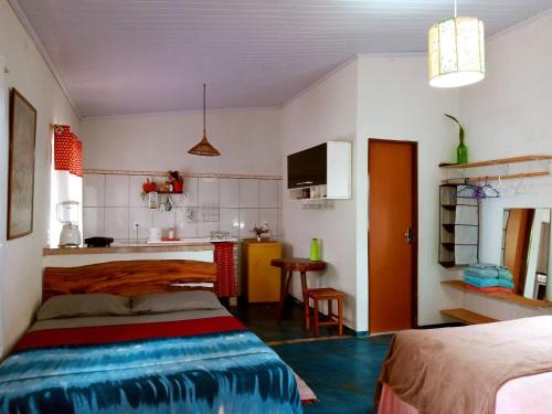 a small room with a bed and a kitchen at Villa Ágape - Chapada dos Veadeiros in Alto Paraíso de Goiás