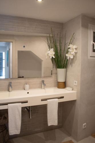 a bathroom with a sink and a vase with flowers at Apartamento Catòlics 25 in Pollença