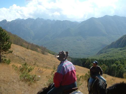 two people riding horses on a hill overlooking mountains at Agriturismo Miralago in Scanno