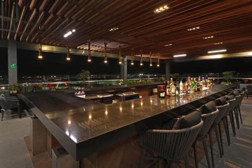 a large bar in a restaurant with chairs around it at Holiday Inn & Suites - Mexico Felipe Angeles Airport by IHG in Zumpango de Ocampo
