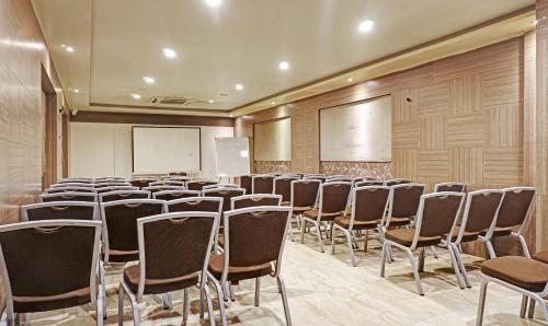 a room with rows of chairs and a whiteboard at Hotel Madhav International Pune Railway Station in Pune