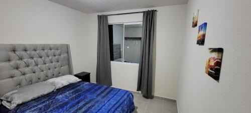 a bedroom with a bed and a large window at Departamento Aeropuerto Puebla in Huejotzingo