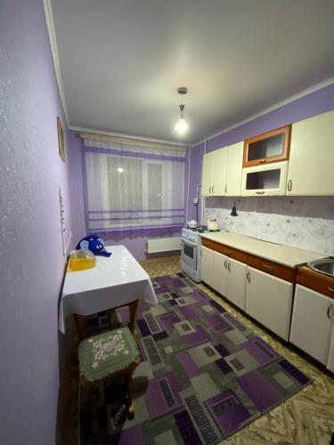een keuken met paarse muren en witte kasten bij Сдам квартиры посуточно in Köksetaw