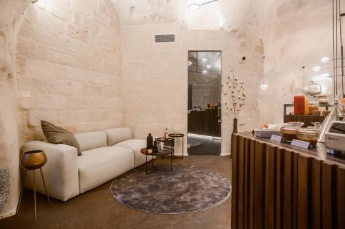 ein Wohnzimmer mit einem weißen Sofa und einem Tisch in der Unterkunft Le Malve Cave Retreat in Matera