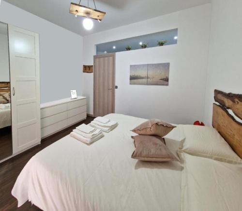 una camera da letto con un grande letto bianco con cuscini sopra di SAINT GEORGE'S HOUSE Bari a Bari