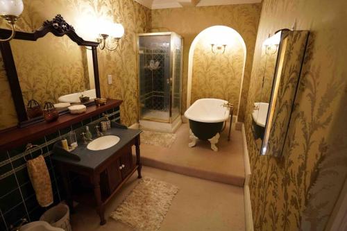 a bathroom with a tub and a sink and a shower at Moulton Grange in Northampton