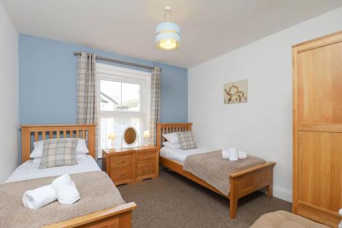 a bedroom with two beds and a window at Kenmare Cottage in Shanklin