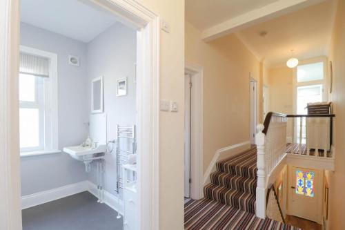 ein Badezimmer mit Waschbecken und eine Treppe mit Waschbecken in der Unterkunft Kenmare Cottage in Shanklin