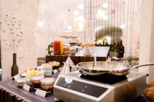 a buffet line with a bowl of food on a counter at Le Malve Cave Retreat in Matera