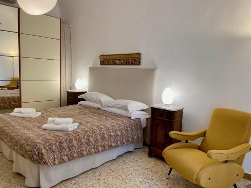 陶爾米納的住宿－Casa Teatro Greco，一间卧室配有一张床和一张黄色椅子