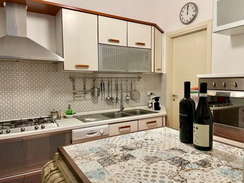 陶爾米納的住宿－Casa Teatro Greco，厨房配有2瓶位于柜台的葡萄酒