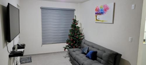 - un salon avec un arbre de Noël et un canapé dans l'établissement Departamento Aeropuerto Puebla, à Huejotzingo