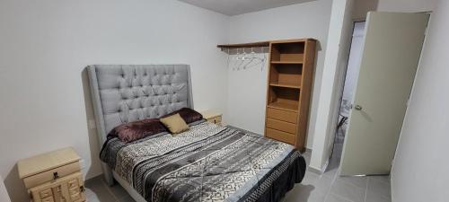 a small bedroom with a bed and a closet at Departamento Aeropuerto Puebla in Huejotzingo