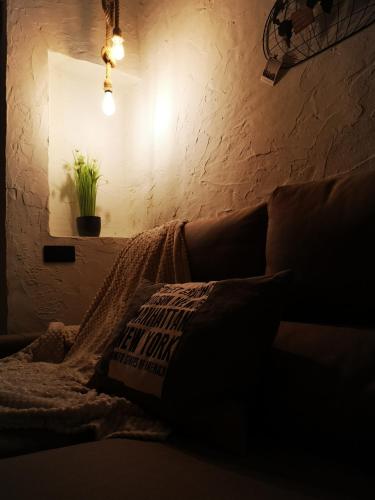 a dark room with a couch with a pillow and a light at Casa Rural El Llano Quintanilla in Yecla