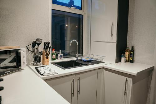 uma cozinha com um lavatório e um micro-ondas em Chatsworth St by Prestige Properties SA em Barrow in Furness
