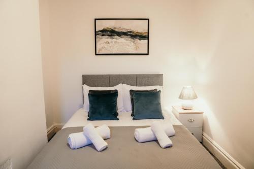 a bedroom with a bed with blue and white pillows at Chatsworth St by Prestige Properties SA in Barrow in Furness