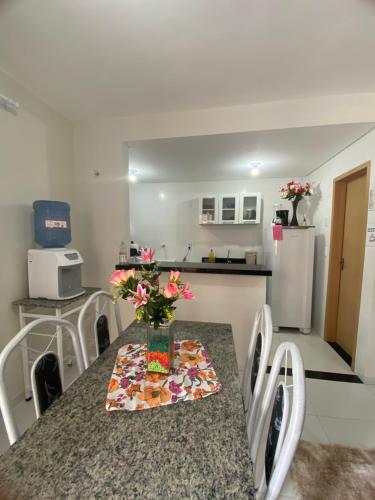 a kitchen with a table with a vase of flowers on it at Apartamento nos Lencois Confort in Barreirinhas
