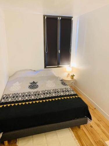 une chambre avec un lit dans une pièce avec une fenêtre dans l'établissement Petit cocon à 2 pas de la cathédrale&hortillonages, à Amiens