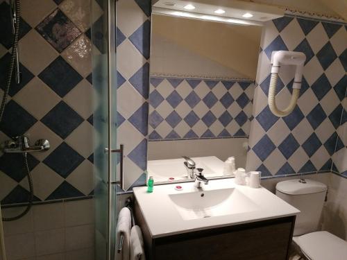 a bathroom with a sink and a shower at Hôtel Le Lievre Blanc in Vars
