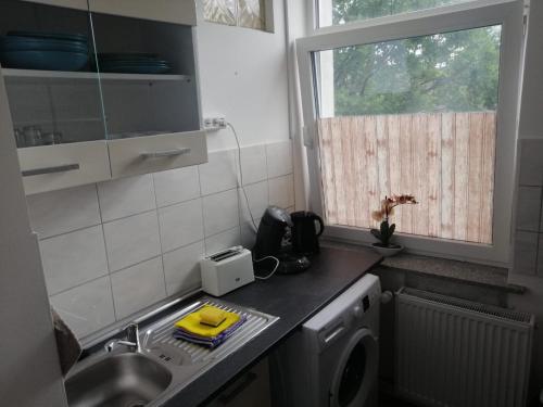 eine Küche mit Spüle und Waschmaschine in der Unterkunft Wohnung in Köln 1B in Köln