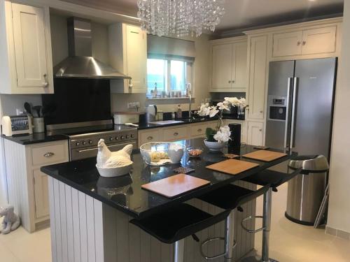 uma cozinha com uma bancada preta e uma geladeira em Villa Oleander Agios Nikolaos Loutra Edipsou em Loutra Edipsou