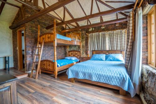 a bedroom with two bunk beds and a ladder at Cabaña sobre el Lago de Tota in Aquitania