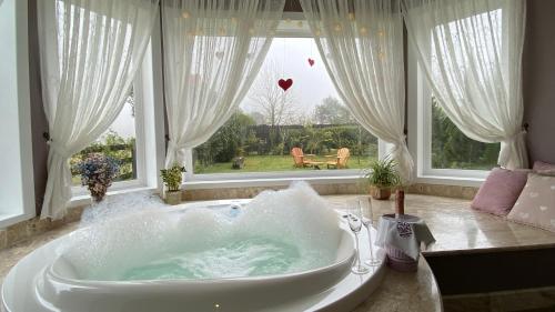 a bath tub in a room with a large window at Pousada Cantos e Encantos in Urubici