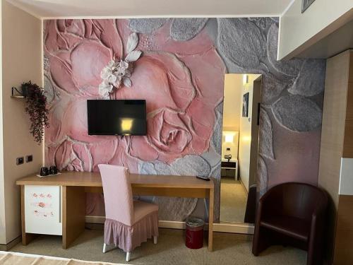 Zimmer mit einem Schreibtisch und einer rosa Wand in der Unterkunft Hotel Sporting Brugherio in Brugherio