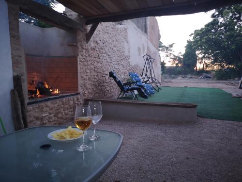 a table with two glasses of wine and a fire pit at Casa Rural El Llano Quintanilla in Yecla